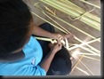 Mah Meri-Frauen zeigen uns das Kunsthandwerk des Flechtens mit Streifen von Palmenblättern, Museumsdorf der Mah Meri auf Pulau Carey